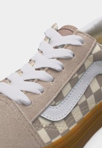 Baskets à carreaux beige et blanc avec des lacets blancs, des détails en daim beige, une bande latérale blanche et une semelle en caoutchouc gomme, vues de profil.