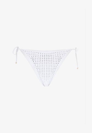Parte inferiore di bikini bianca con borchie argentate disposte in un motivo. Cinghie laterali con dettagli dorati alla fine delle cinghie.