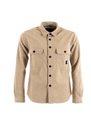 Beige overhemd met lange mouwen en knoopsluiting, voorzien van twee borstzakken, zwarte knopen en een klein zwart logo-patch op de linkse zak.