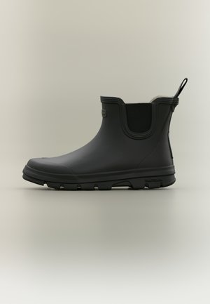 Bottine noire en caoutchouc avec un design élégant, semelle texturée et embout renforcé. Dispose d'une languette pour un enfilage facile et d'une doublure douce.