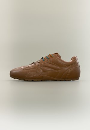 Brązowy skórzany sneaker z przeszywanym wzorem i mieszanymi brązowymi oraz niebieskimi sznurowadłami na jednolitym jasnym tle.