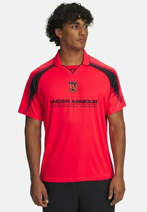 Man wearing bright red Under Armour short-sleeve performance shirt with black accents, standing against plain white background.