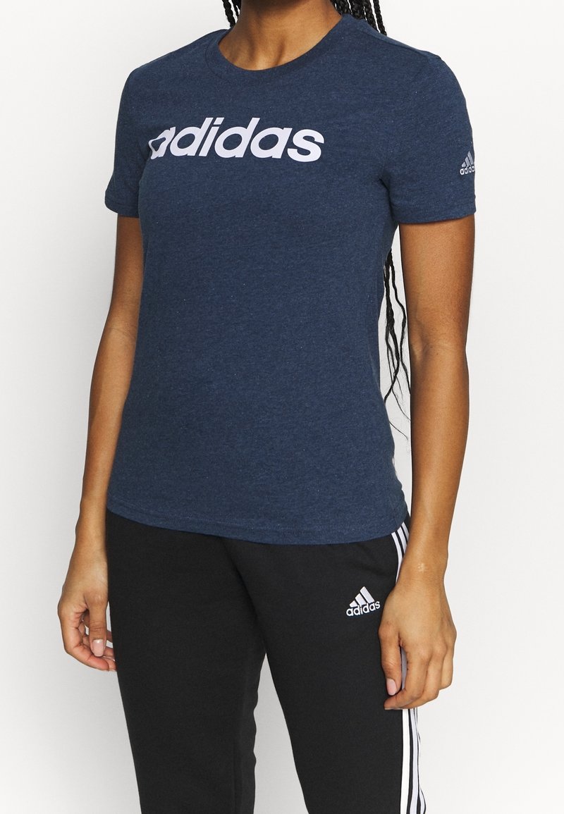 Granatowa koszulka bawełniana z dużym białym logo "adidas" na klatce piersiowej. Krótkie rękawy, okrągły dekolt, miękka tekstura.