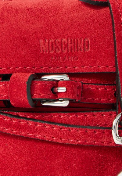 Raudona veliūrinė rankinė su iškilniu "Moschino Milano" logotipu, sidabrinėmis detalėmis ir kontrastingo juodo siuvimo siūlines.