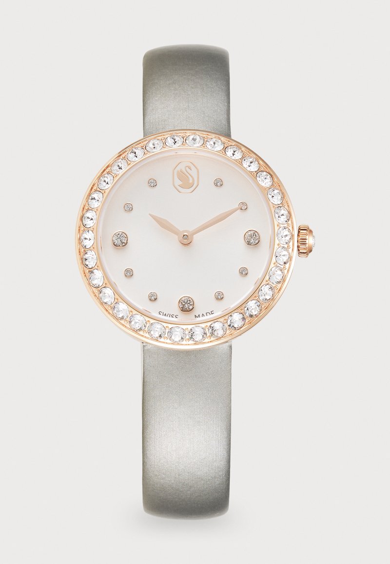Orologio bianco rotondo con cassa in oro rosa e dettagli in cristallo. Cinturino in satin grigio. Quadrante minimalista con lancette e indicatori delle ore dorati. Fabbricato in Svizzera.
