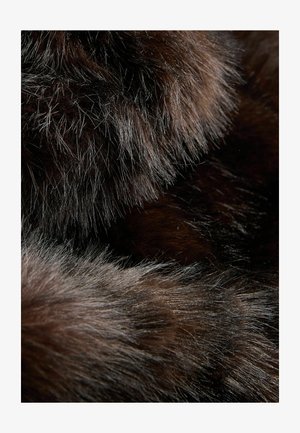 Braunes Stofftier mit einer dichten, weichen Textur. Auffällige lange Deckhaare in helleren Farbtönen, die subtile Farbvariationen und Tiefe erzeugen.