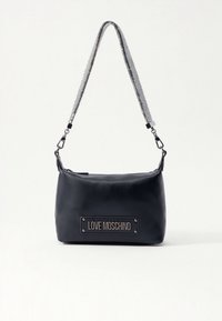 Black Love Moschino -olkalaukku hopeisella ketjuhihnalla, suorakaiteen muotoinen ja etupuolella oleva logolevy.