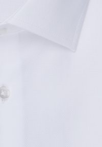 Colletto di camicia bianca e texture con un bottone, caratterizzato da un design classico e un tessuto morbido. Materiale leggero e traspirante.