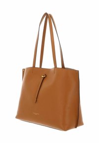 Sac fourre-tout en cuir tan avec une surface lisse et texturée, deux longues poignées et un accent doré. Il dispose d'une fermeture supérieure et d'une marque en relief.