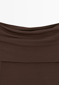 Brown fabric with a wide, folded, draped neckline detail creating soft horizontal layers.