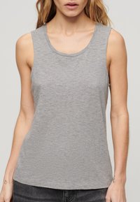 Szary, bezrękawnik wykonany z lekkiego, miękkiego materiału. Posiada okrągły dekolt oraz subtelne logo na klatce piersiowej.