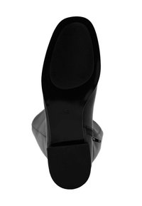 Czarne botki za kostkę z gładkiej skóry, okrągłym noskiem, teksturowaną gumową podeszwą i bocznym zamkiem. Design jest elegancki i smukły.