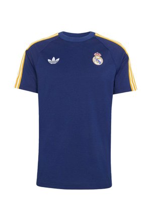 Σπορ μπλουζάκι σε ναυτικό μπλε με κίτρινες ρίγες στα μανίκια, λογότυπο Adidas στη δεξιά πλευρά του στήθους και έμβλημα της Ρεάλ Μαδρίτης στην αριστερή πλευρά.