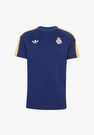 Tmavě modré sportovní tričko se žlutými pruhy na rukávech, logem Adidas na pravé straně hrudi a znakem Realu Madrid na levé straně hrudi.