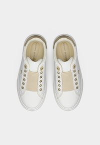 Λευκά παπούτσια σλιπ-ον με μπεζ ελαστική ταινία, χρυσές τρύπες κορδονιών και δερμάτινες λεπτομέρειες. Διαθέτουν στρογγυλεμένη μύτη και ένθετα υφάσματος με υφή.