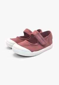 Paire de chaussures rouges fanées pour tout-petit avec bouts en caoutchouc blanc et sangles velcro ajustables sur fond blanc.