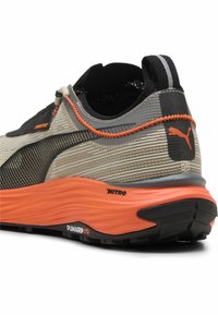 Scarpa da corsa con una leggera tomaia in rete grigia, suola in gomma arancione e accenti neri. Presenta un design texturizzato e il logo PUMA.