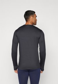 Long-sleeve black shirt made of smooth fabric, featuring a crew neck and fitted design, viewed from the back. Seam detailing near cuffs.