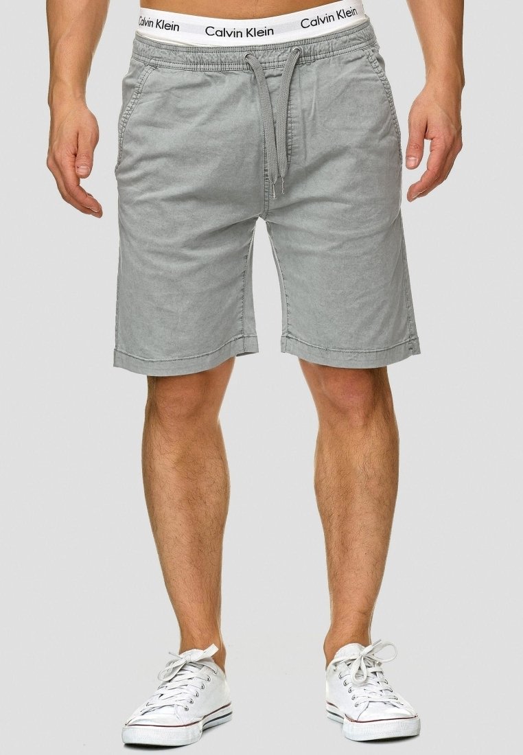 Shorts en coton gris avec une taille élastique arborant un logo Calvin Klein visible, une fermeture à cordon et des poches latérales.