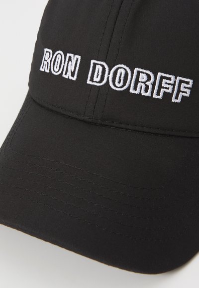 Casquette de baseball noire en tissu, avec le texte brodé blanc "RON DORFF" à l'avant, dotée d'un design structuré et d'une visière courbée.