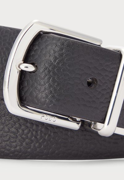 Ceinture en cuir noir avec une surface texturée, boucle rectangulaire en argent et marquage de la marque "POLO" près de la boucle.