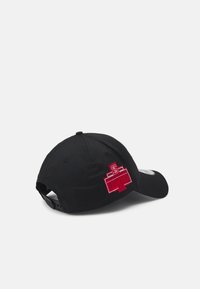 Schwarze Stoffmütze mit einem gebogenen Schirm, ausgestattet mit einem roten gestickten Logo und Text an der Seite, verstellbarer Snapback-Verschluss hinten.