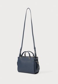 Sac à main en cuir bleu marine avec des poignées supérieures doubles et une bandoulière longue et réglable. Comprend une poche zippée et des accents en métal doré.