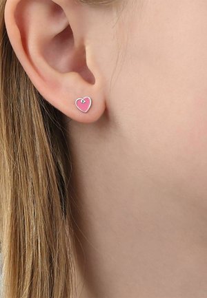 Primo piano di un orecchio sinistro con un piccolo orecchino a perno a forma di cuore rosa con bordi argento.