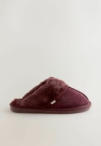 Bordeauxfarbene Hausschuhe mit einem weichen Kunstfellfutter, Obermaterial aus weichem Stoff und einer gepolsterten Sohle für zusätzlichen Komfort. Am Seitentägelchen ist der Markenname angebracht.