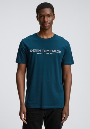 Teal cotton t-shirt with short sleeves, crew neck, and front print: "DENIM TOM TAILOR ESTABLISHED 2007" in gray lettering.