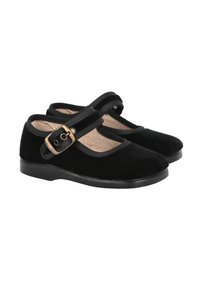 Zapatos Mary Jane negros con diseño de puntera partida redondeada, correa ajustable, hebilla de latón y suela plana sobre un fondo blanco.