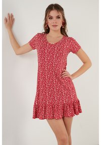 Rode jurk met korte mouwen, witte bloemenprint, ronde halslijn en een tiered ruffle zoom. Heeft een getailleerde silhouet en zachte stof.
