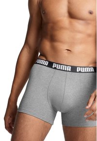 Gray cotton boxer briefs feature a black waistband with white "Puma" logo. The fabric is soft with a smooth texture and fitted design.