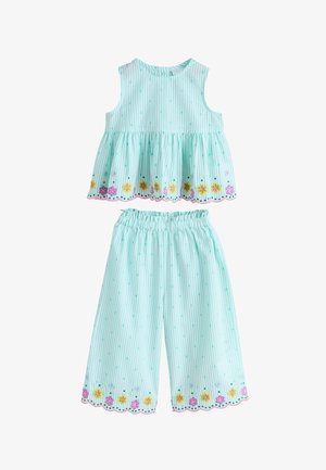 Ärmelloses türkis gestreiftes Top und passende elastische Bundhose mit gezackten Säumen und bunten bestickten Blumen am Rand.