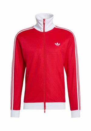 Rode zip-up jas met witte accenten, hoge kraag en drie witte strepen op de mouwen. Bevat een klein wit logo op de borst.