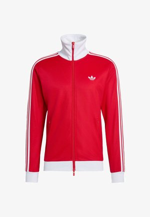 Rode zip-up jas met witte accenten, hoge kraag en drie witte strepen op de mouwen. Bevat een klein wit logo op de borst.