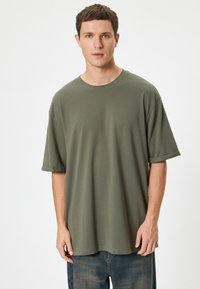 Oliven grøn oversized t-shirt lavet af blødt bomuld, med rund hals, korte ærmer og en afslappet pasform. Ingen synlige mønstre.