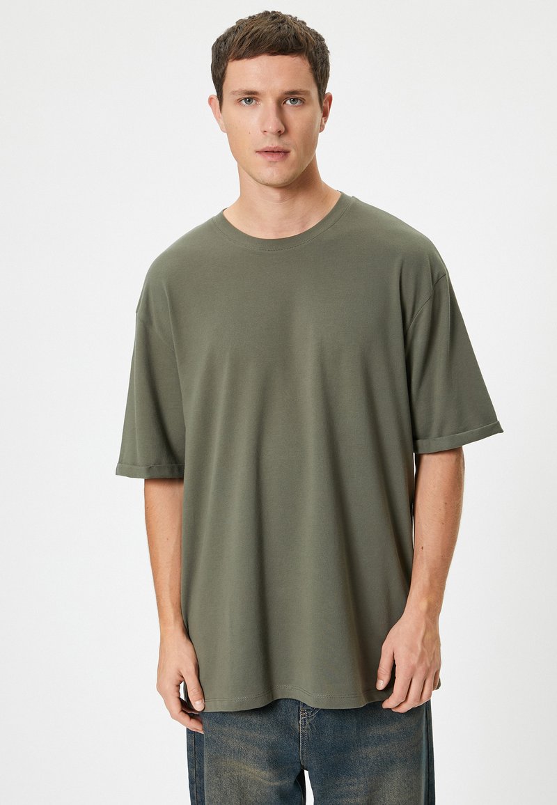 Oliven grøn oversized t-shirt lavet af blødt bomuld, med rund hals, korte ærmer og en afslappet pasform. Ingen synlige mønstre.