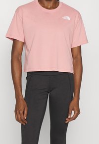 Roze cropped t-shirt van zacht katoen met een ronde halslijn en korte mouwen. Bevat een wit logo op de linkerkant van de borst.