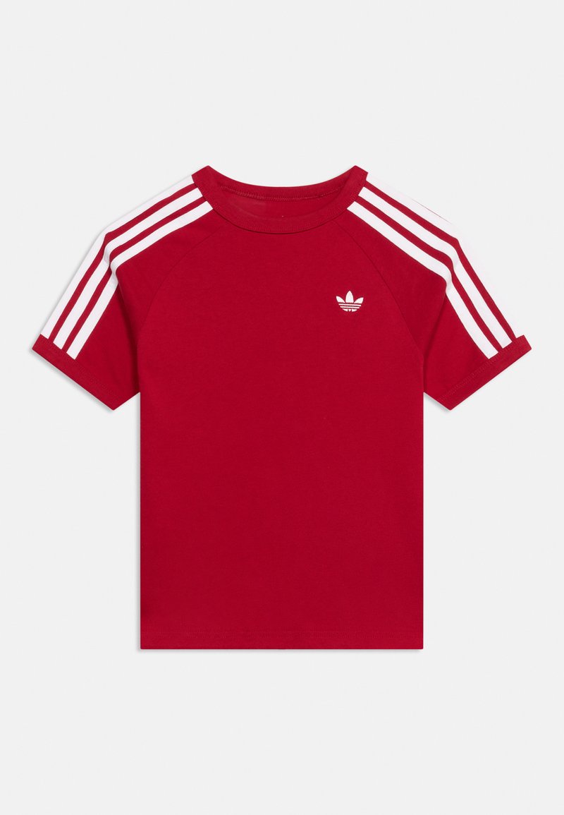 T-shirt rouge à manches courtes avec des détails à trois bandes blanches sur les épaules et un petit logo blanc Adidas sur la poitrine.