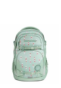 Green backpack with a polka dot pattern in red and white. Features zippers, straps, and a round logo patch. Soft fabric with padded grips.