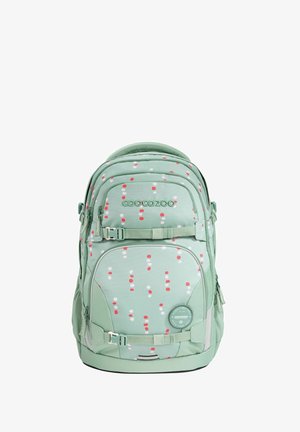 Grüner Rucksack mit einem roten und weißen Punktenmuster. Enthält Reißverschlüsse, Riemen und ein rundes Logopatch. Weicher Stoff mit gepolsterten Griffen.