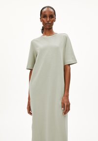 Helles grünes, kurzärmliges Kleid aus weichem Stoff, das einen lockeren Schnitt und einen runden Halsausschnitt aufweist, mit glatter Textur und ohne sichtbare Muster.
