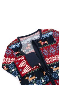 Červený a námořnický zip-up overal s vánočními vzory, který obsahuje sněhové vločky, vánoční stromečky a jezevčíky v svetrech. Měkká textura látky.