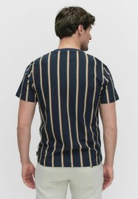 Navy gestreepte t-shirt met korte mouwen, met om en om lichtbruine en beige strepen. Standaard ronde hals en een ontspannen pasvorm ontwerp.