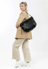 Black leather shoulder bag with a soft, rounded shape and subtle texture. Features a top zip closure and a decorative strap.