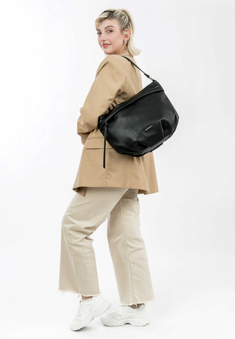 Black leather shoulder bag with a soft, rounded shape and subtle texture. Features a top zip closure and a decorative strap.