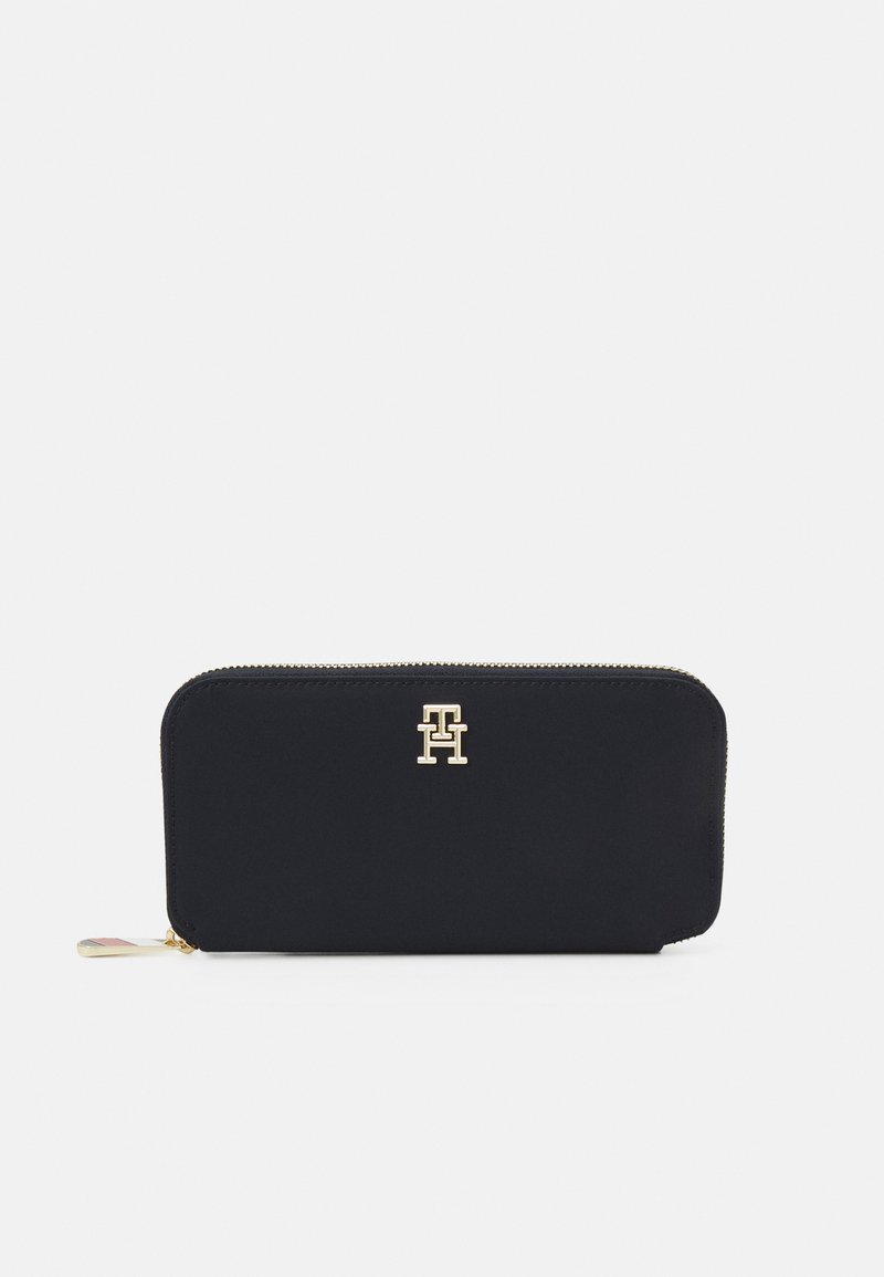 Black zip-around wallet in smooth fabric, featuring a gold logo on the front and a contrasting zipper pull with brand colors.