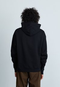 Sweatshirt preto com capuz, de corte relaxado, apresentando um grande capuz, punhos canelados e uma barra, confeccionado em um tecido macio com costuras mínimas.
