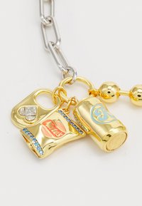Collana con charm in tonalità oro che presenta tre charm: un lucchetto a forma di cuore con un accento di diamante, un barattolo per snack etichettato in rosa e un barattolo con un accento blu.